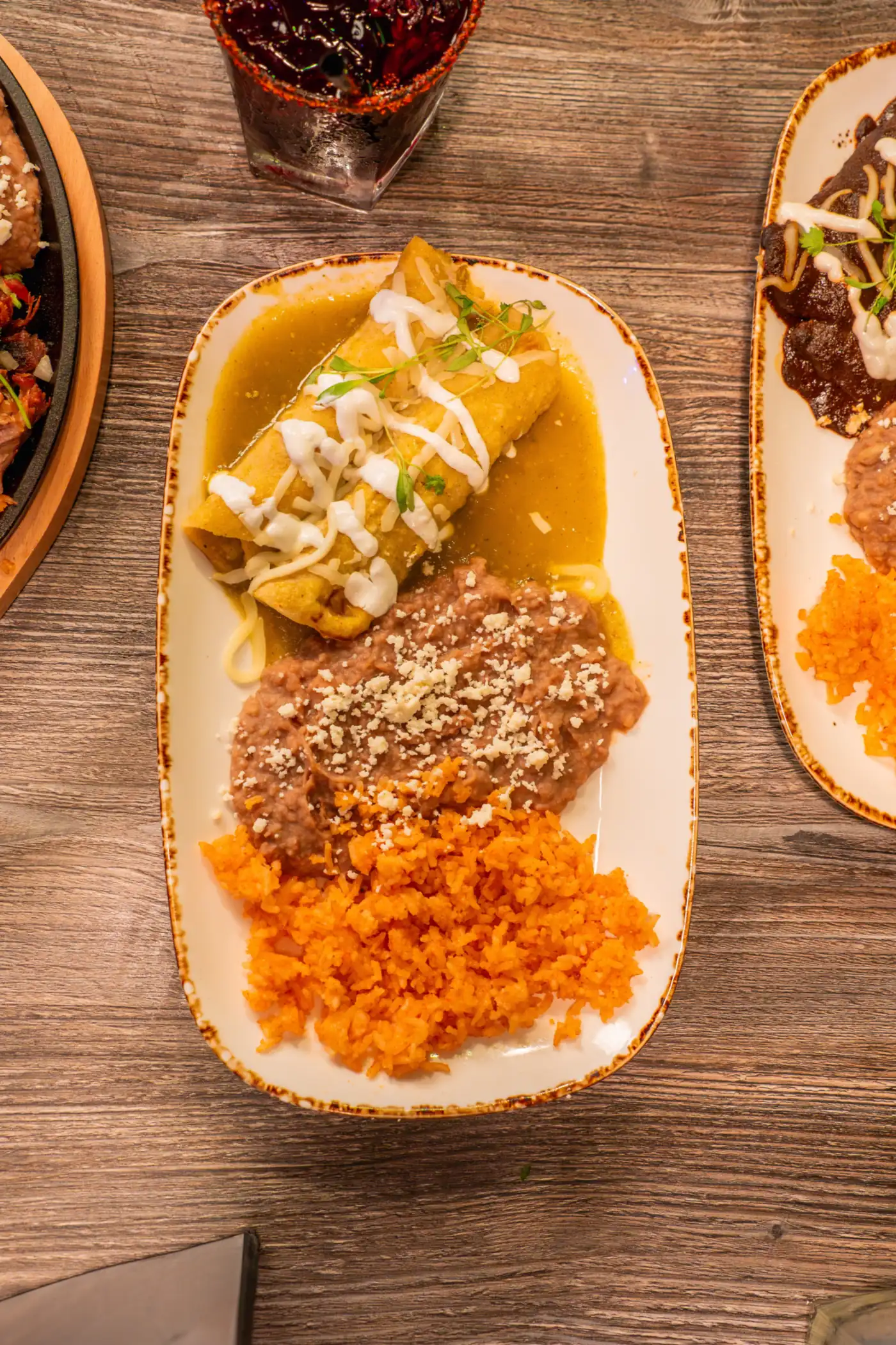 Enchiladas verdes plate with refried beans and Mexican rice