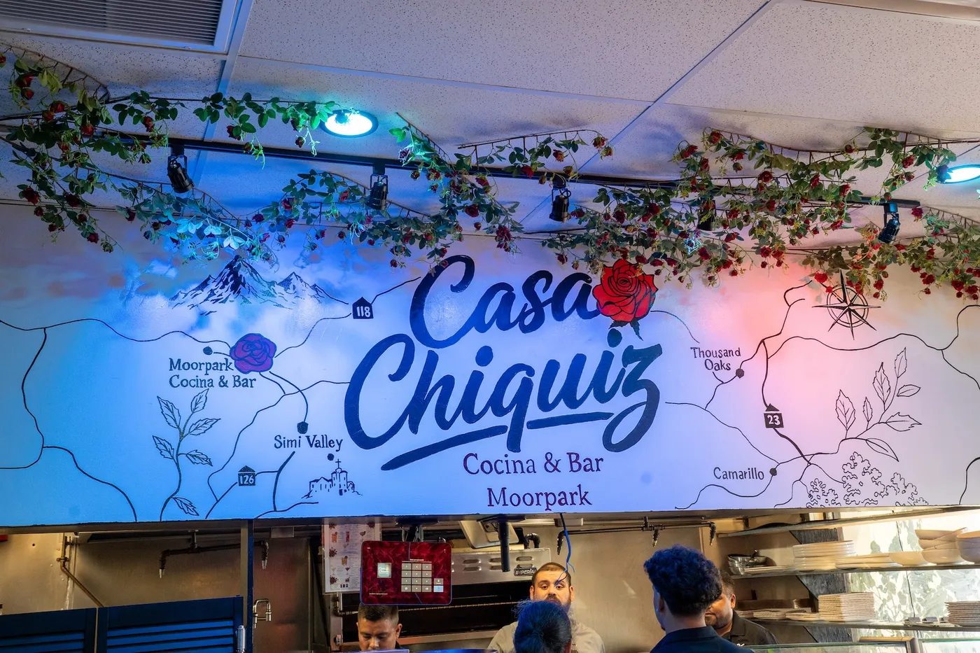 Hand-painted Moorpark map mural with vine canopy above the open kitchen line